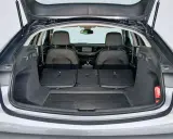 Maletero abierto de un Opel Insignia gris, mostrando asientos traseros abatidos y espacio de carga. Ideal para conocer las medidas del maletero.