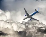Flygplan kämpar sig fram genom mörka moln, en dramatisk scen av turbulens i luften.