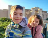 Dos niños sonríen frente al Palacio de la Aljafería, un lugar genial que ver en Zaragoza con niños.