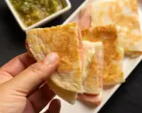 Ciepłe quesadille z szynką i serem, idealne na szybką kolację. Obok sos.
