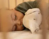 Dulce sueño de bebé de 6 meses, abrazando su peluche mientras duerme plácidamente en su cuna.