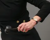 Auctioneer's hand with a gavel, ready to finalize an art loan.