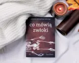Książka "Co mówią zwłoki" Sue Black, opowieści antropologa sądowego, leży obok zapalonej świecy i jesiennych liści.