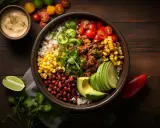 Kolorowy burrito bowl z ryżem, fasolą, kukurydzą, mięsem mielonym, awokado, pomidorkami i jalapeno.