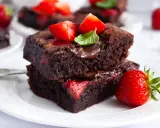 Pyszne brownie z truskawkami, polane czekoladą i ozdobione świeżymi owocami. Idealne na deser!