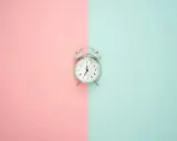 Budzik na pastelowym tle. Pokazuje 7:00, czas na rozpoczęcie dnia, czy to am, czy pm, zawsze jest dobry moment na zmianę.
