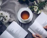 Kawa i kwiaty obok otwartych książek po angielsku online za darmo. Idealny sposób na relaks i naukę.