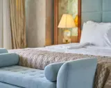 Elegancka sypialnia hotelowa z wygodnym łóżkiem i sofą. Spełnia wszelkie **hotel 4 gwiazdki wymagania** dotyczące komfortu i stylu.