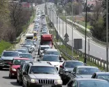 Korek na drodze, jak węzeł gordyjski, zablokował ruch. Samochody stoją w długiej kolejce, tworząc niekończący się rząd pojazdów.