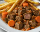 Tierna ternera en salsa con patatas fritas y zanahorias. Un plato reconfortante y delicioso.