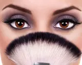 Occhi grandi e tondi esaltati da un trucco smokey viola e ciglia finte, con un pennello da trucco in primo piano.