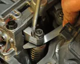 Mechanik reguluje luzy zaworowe, używając śrubokręta i szczelinomierza.