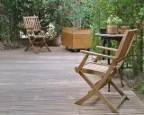 Deux chaises en bois sur une terrasse. Pour savoir comment protéger un meuble de l'humidité, pensez à un traitement hydrofuge.