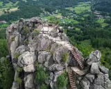 Widok z góry na skalny masyw Sokolik Duży, z platformą widokową i schodami prowadzącymi na szczyt. W tle zielone wzgórza i lasy.