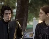 Ragazzo con giacca di pelle e ragazza con cappotto a righe, forse protagonisti di "Fabbricante di lacrime", si guardano intensamente.