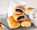 Bollo de chocolate recién horneado, con relleno cremoso, apilado sobre una rejilla.