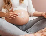 Ciężarna kobieta rysuje uśmiechniętą buźkę na brzuchu. Myśli o przyszłości, o zdrowiu dziecka i o tym, jak cenna jest krew pępowinowa.