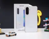 Biały Samsung Galaxy A36 5G, produkt największego producenta smartfonów, obok miniatury Japonii i modelu samochodu.