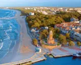 Malownicze miejscowości nad morzem z latarnią morską, plażą i portem.
