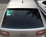 El coche plateado tiene una L verde en el lado izquierdo de la ventana trasera, indicando que el conductor está aprendiendo.