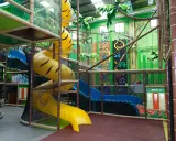 Un divertido parque infantil en Madrid con toboganes amarillos y azules, rocódromos y una piscina de bolas.