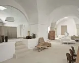 Interni moderni con volte a stella, arredi minimalisti e vasi decorativi.