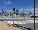 Parcheggio rimini con strisce pedonali e segnaletica, sullo sfondo un treno blu.