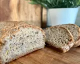 Chleb keto przepis. Domowy, puszysty bochenek z chrupiącą skórką, pokrojony na kromki, leży na desce.