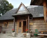Drewniany budynek muzeum górali i zbójników z charakterystycznym trójkątnym okienkiem nad wejściem.