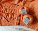 Pomarańczowy sweter z pięknymi wzorami na drutach, włóczka baby alpaca i druty.