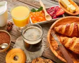 Pyszne śniadanie kontynentalne: świeże croissanty, dżemy, masło, sok pomarańczowy i kawa. Idealny początek dnia!