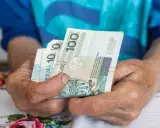 Dłonie trzymają polskie banknoty. Zastanawiasz się, ile może zająć ZUS z wynagrodzenia?