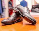 Eleganckie, brązowe półbuty męskie z ażurowymi zdobieniami. Zastanawiasz się, co to zelówka? To podeszwa buta, która zapewnia komfort i przyczepność.