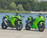 Dwa zielone Kawasaki Ninja 250 stoją nad wodą. Poznaj kawasaki ninja 250 dane techniczne i poczuj moc!