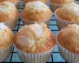 Magdalenas de naranja recién horneadas, doradas y espolvoreadas con azúcar, listas para disfrutar.