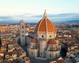 Vue aérienne de la **cattedrale Santa Maria** del Fiore et de son campanile, dominant les toits de Florence au lever du soleil.