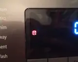 Pralka Samsung wyświetla czerwony symbol bębna z kryształkami, wskazujący na problem z odprowadzaniem wody. To jeden z kodów błędów.