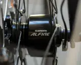 Szczegół piasty rowerowej Shimano Alfine z widocznym kablem, który jest kluczowy, by dowiedzieć się jak włączyć dynamo w rowerze.