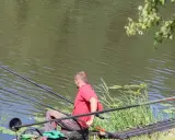 Dwóch wędkarzy nad jeziorem Węgorzyno. Jeden z nich właśnie wyciąga rybę.