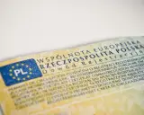 Dowód rejestracyjny pojazdu, niezbędny do ubezpieczenia samochodu, z flagą PL i tekstem w wielu językach.