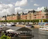 En dag i Stockholm vid vattnet med vackra byggnader, båtar och uteserveringar.