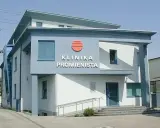Nowoczesny budynek kliniki "Promienista" w Poznaniu z niebieskimi elementami i logo.