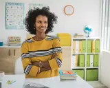 Insegnante sorridente in aula, pronta ad aiutare chi ha diritto all'insegnante di sostegno.