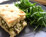Une focaccia au fromage généreusement garnie d'épinards, servie avec une salade verte fraîche.