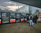 Buss vid flygplatsen, redo att ta resenärer från prag flygplats till centrum. En modern byggnad syns i bakgrunden.