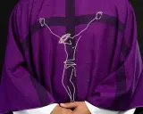 Fioletowa szata liturgiczna z haftowanym wizerunkiem Jezusa na krzyżu.