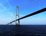 El puente del Gran Belt se extiende majestuosamente sobre el mar azul bajo un cielo despejado.