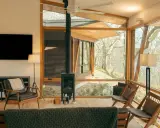 Salon moderne avec poêle à granulés 8 kw. Combien de m2 peut-il chauffer ? Fenêtres panoramiques, mobilier design, vue sur la nature.