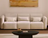 Sofá beige con cojines, mesa de centro oscura, alfombra clara y cuadro abstracto. Los colores feng shui crean un ambiente sereno.