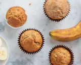 Saftige bananen muffins, ein reifer Banane und Bananenscheiben auf einem Teller. Perfekt für den Kaffeetisch.